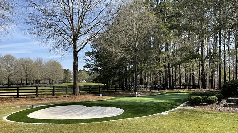 Advanced artificial turf technology in a custom putting green designed by Southern Greens, enhancing golf practice at a Montgomery residence.